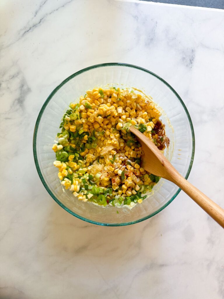 mixing corn fritter ingredients in large bowl