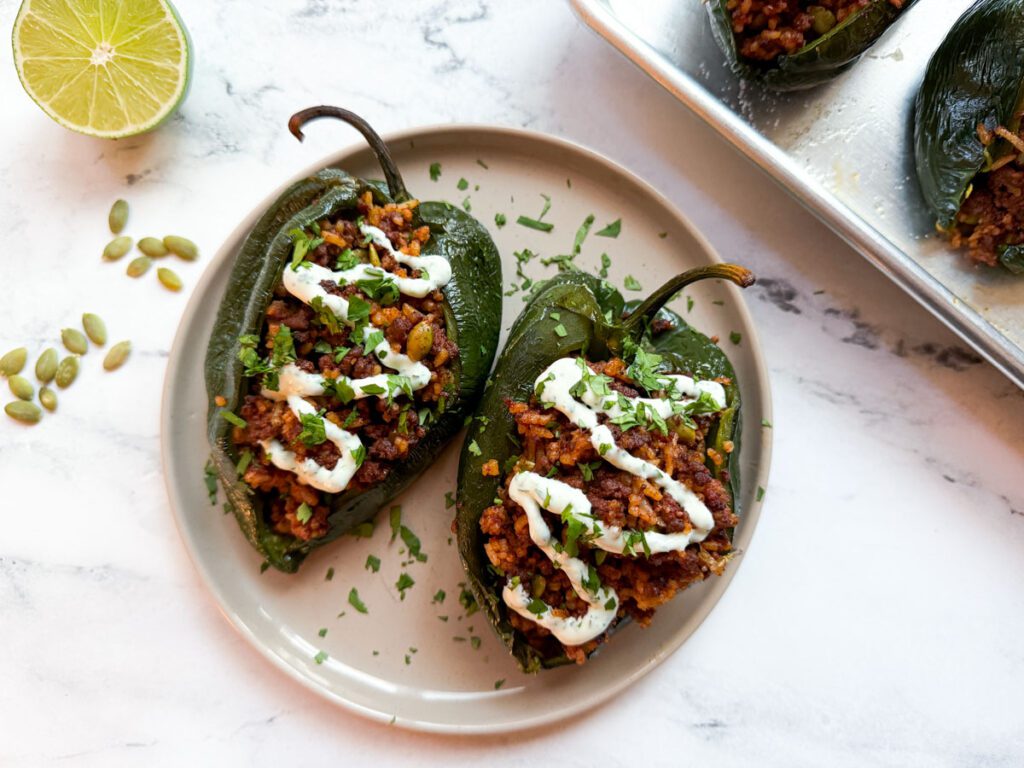 stuffed poblano peppers served with a drizzle of cilantro lime crema and chopped cilantro